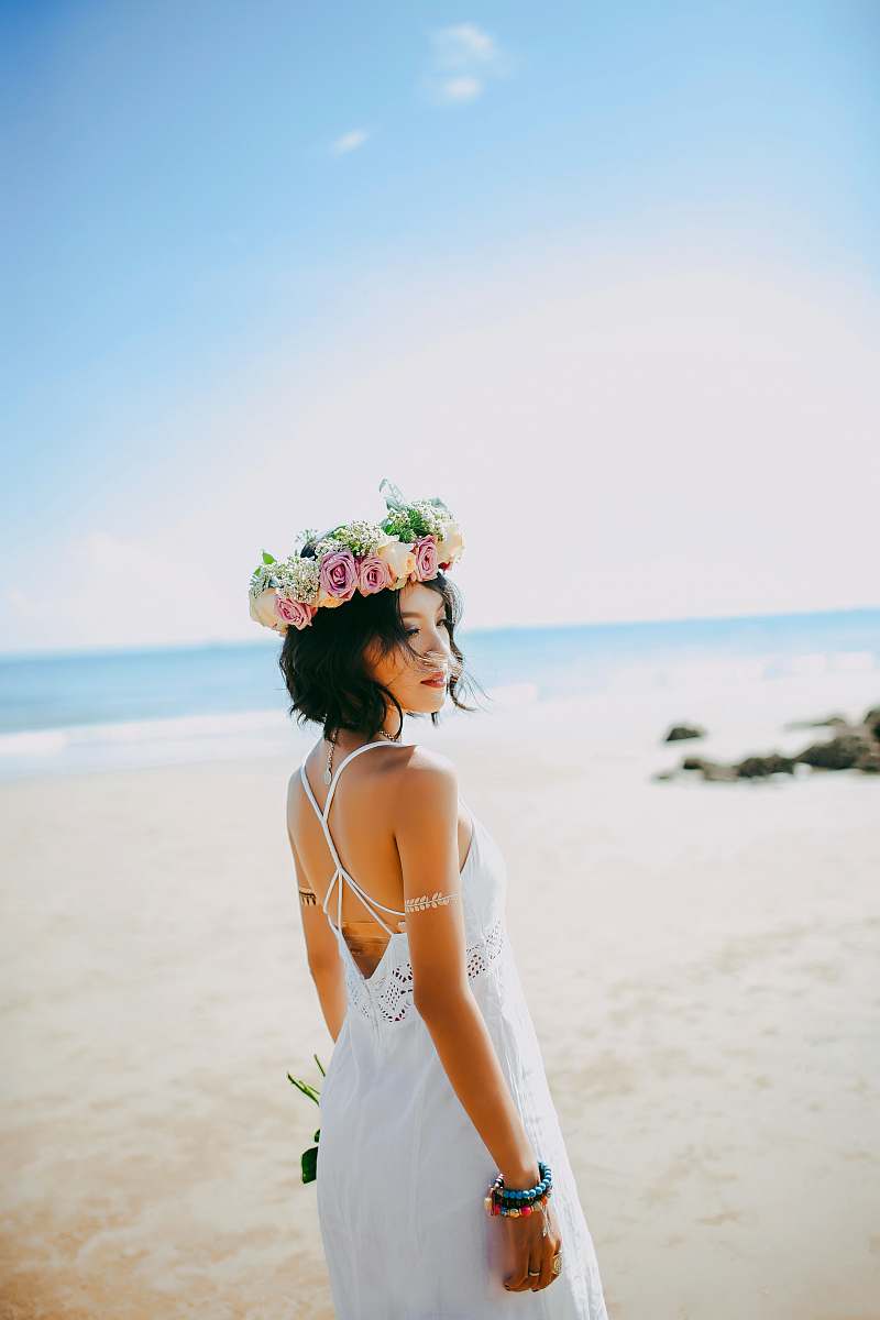 people woman wearing white spaghetti-strap dress standing on the seashore during daytime photography human