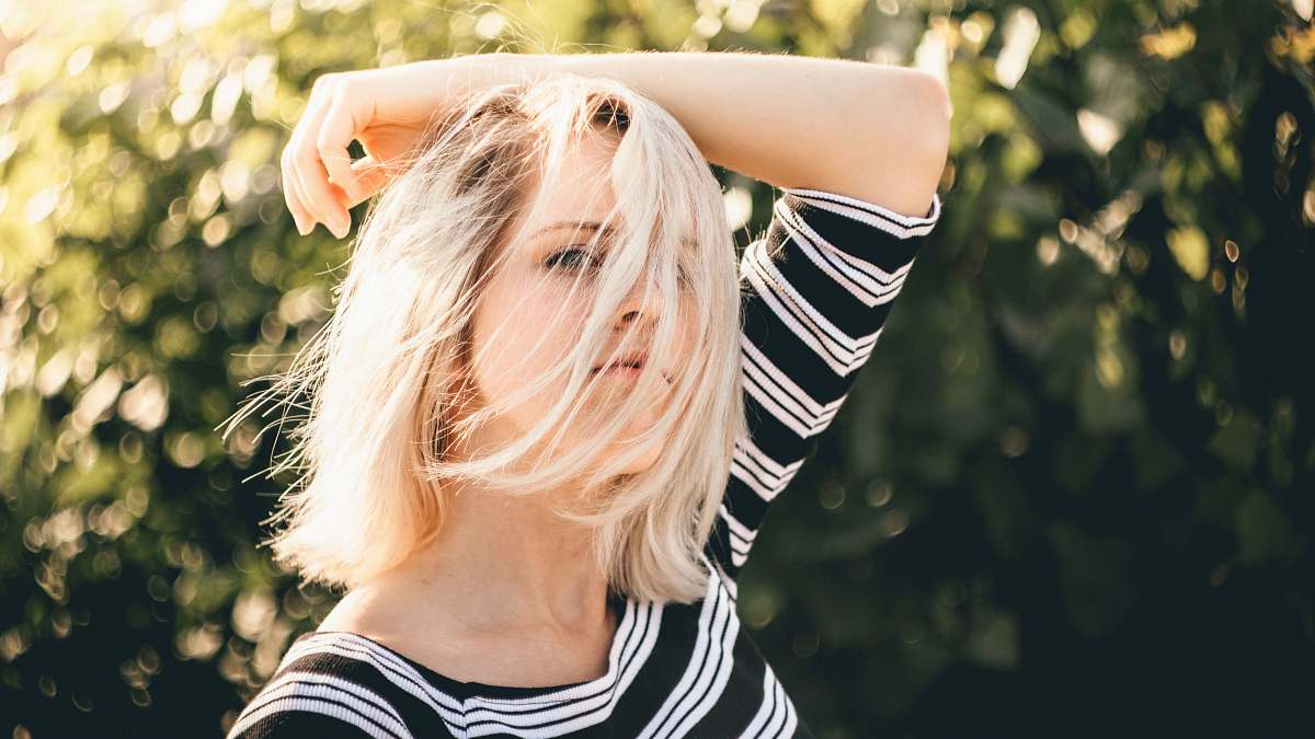 blonde shallow focus photography of woman in black and white striped top girl