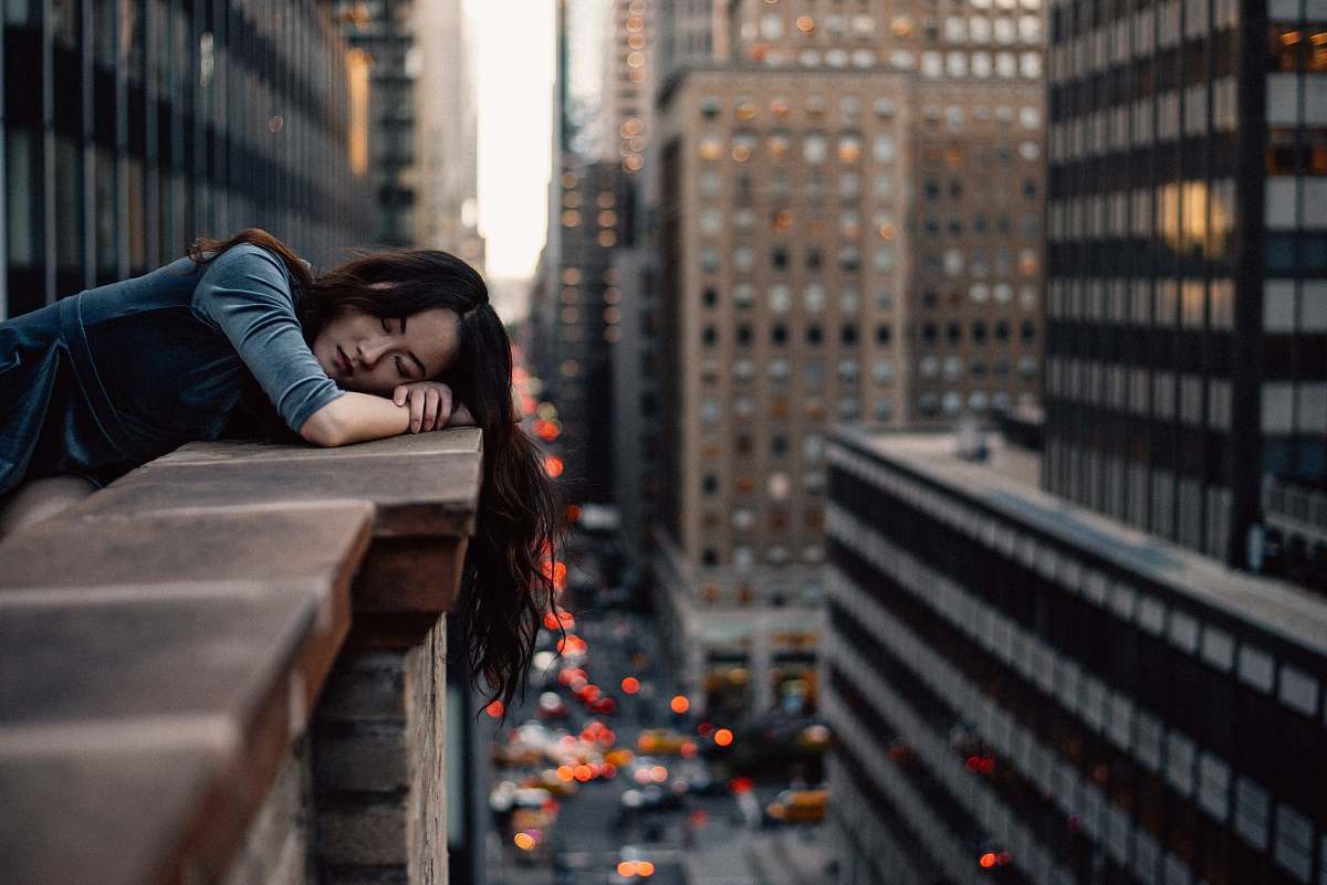 people woman leaning on top building rail during daytime building
