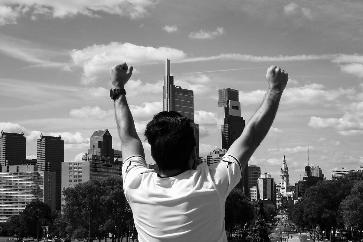 building man raising both arms city