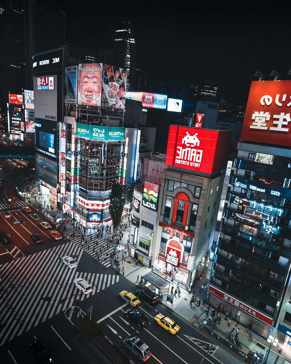 city aerial photography of commercial buildings and vehicles on road during nighttime metropolis
