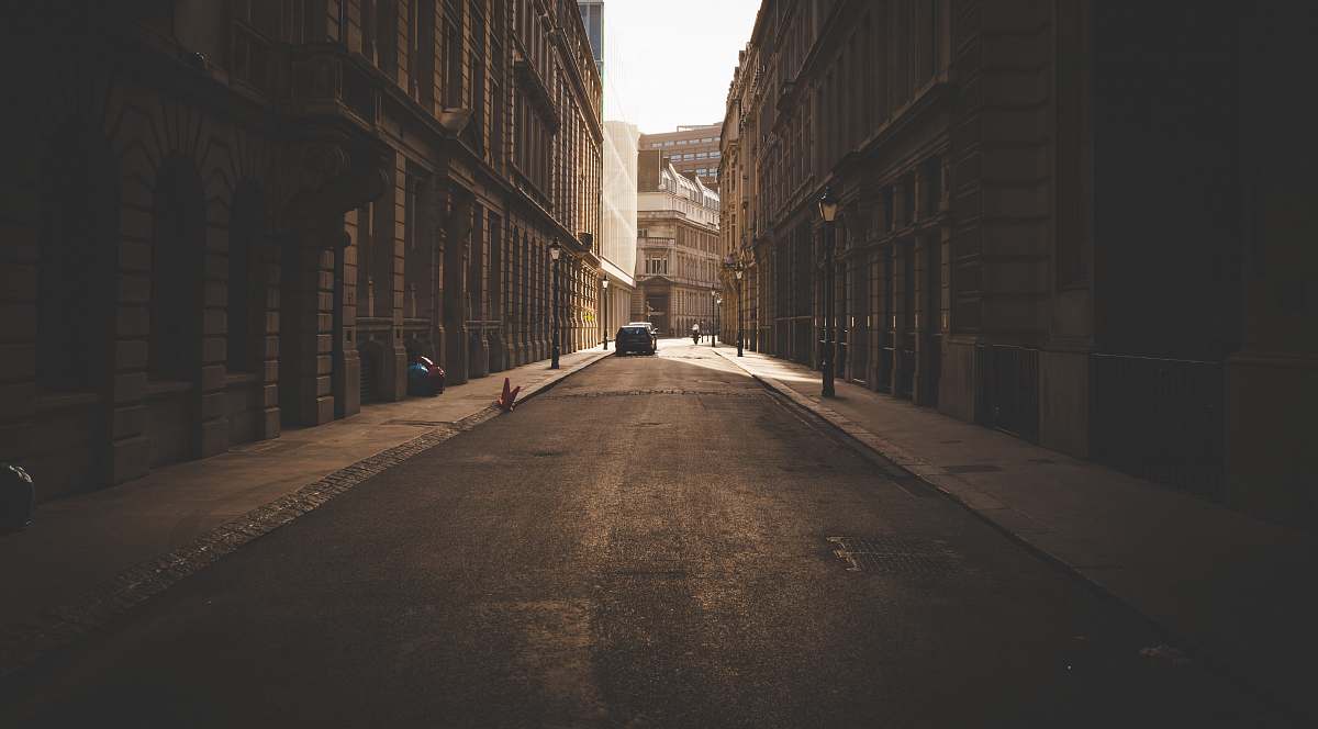 road architectural photography of vehicle between two buildings street