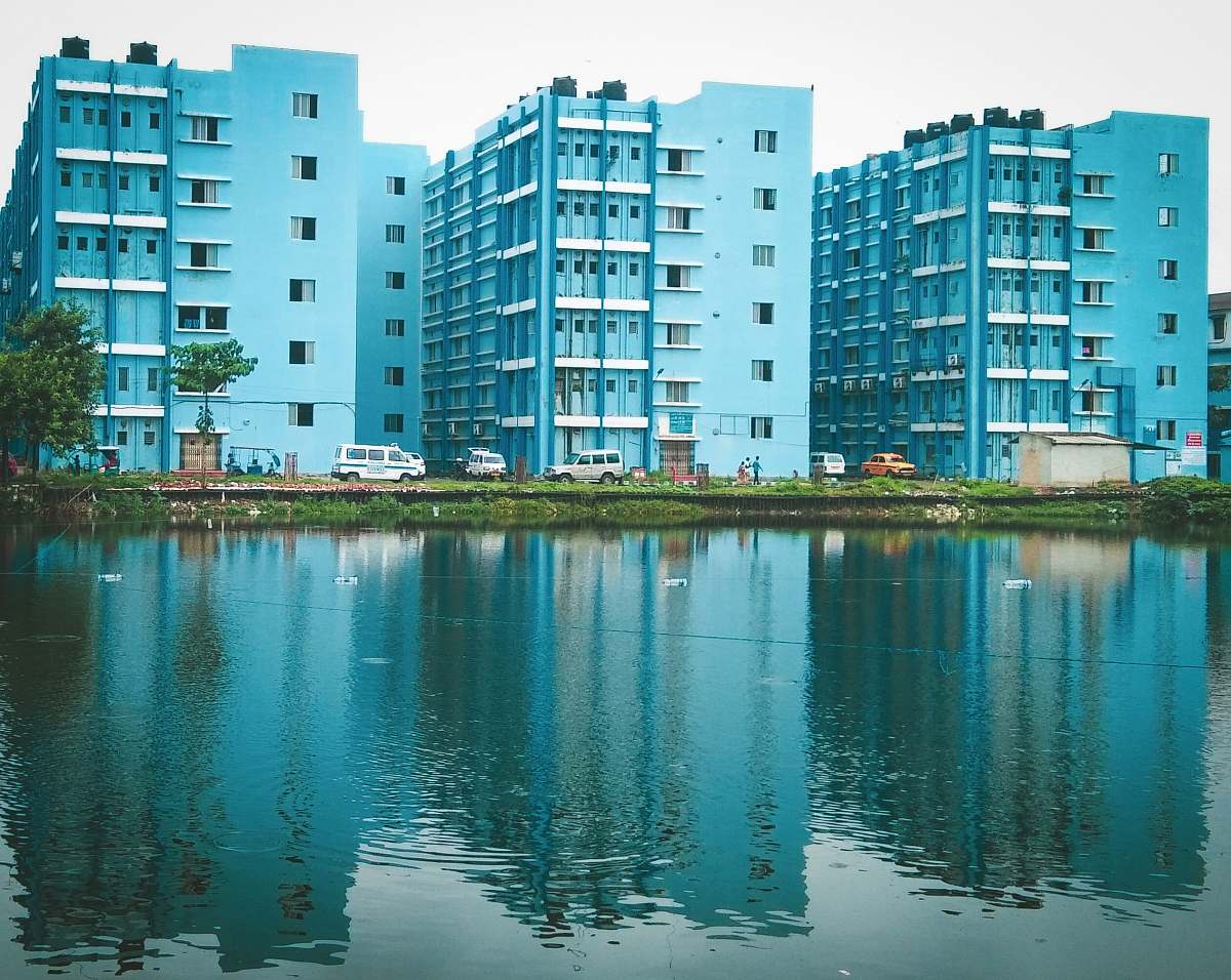 city blue painted buildings beside body of water high rise