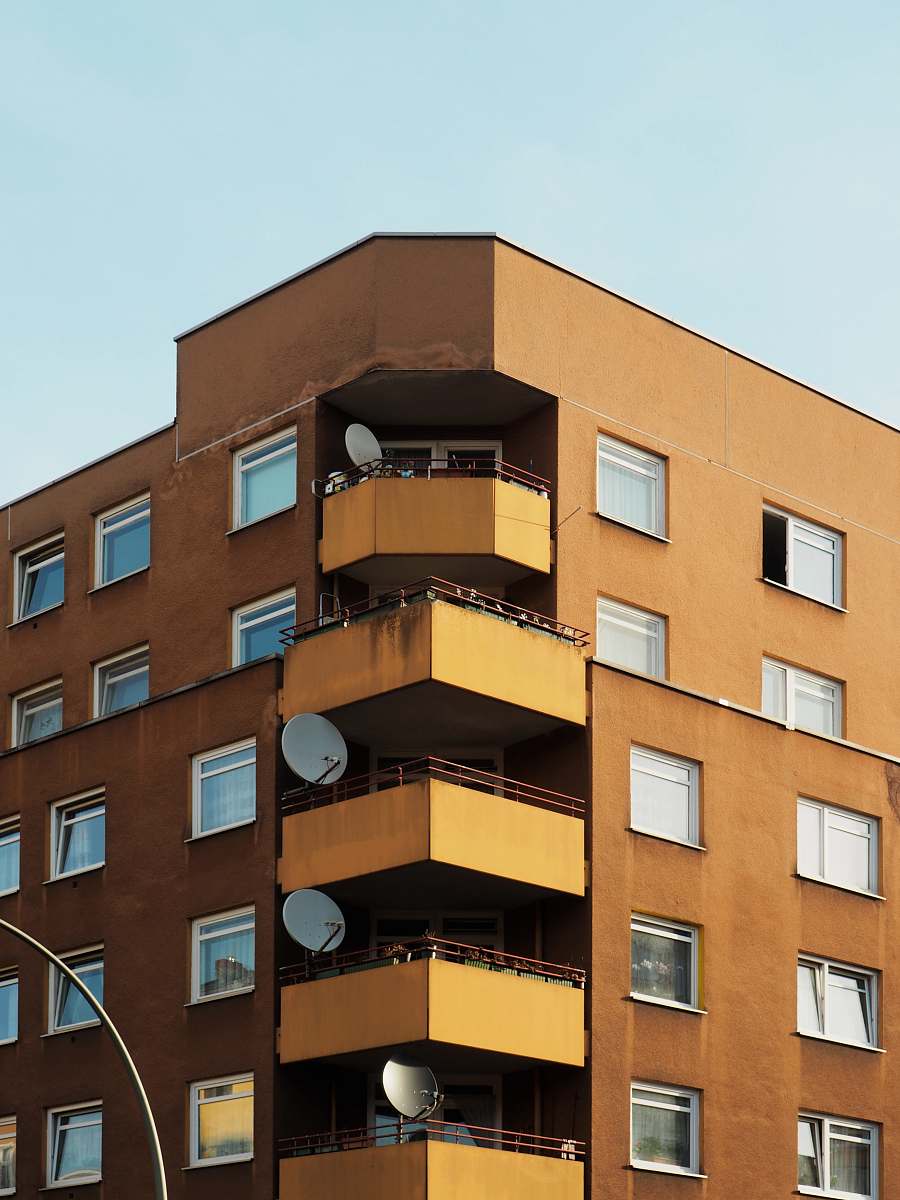 city brown building with parabollic antenna during daytime high rise