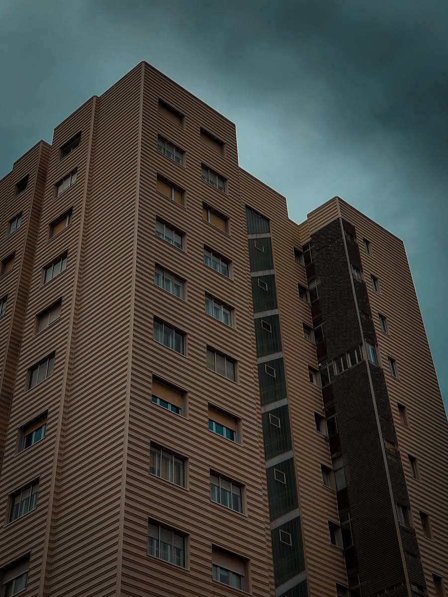 city brown buildings under gray clouds high rise