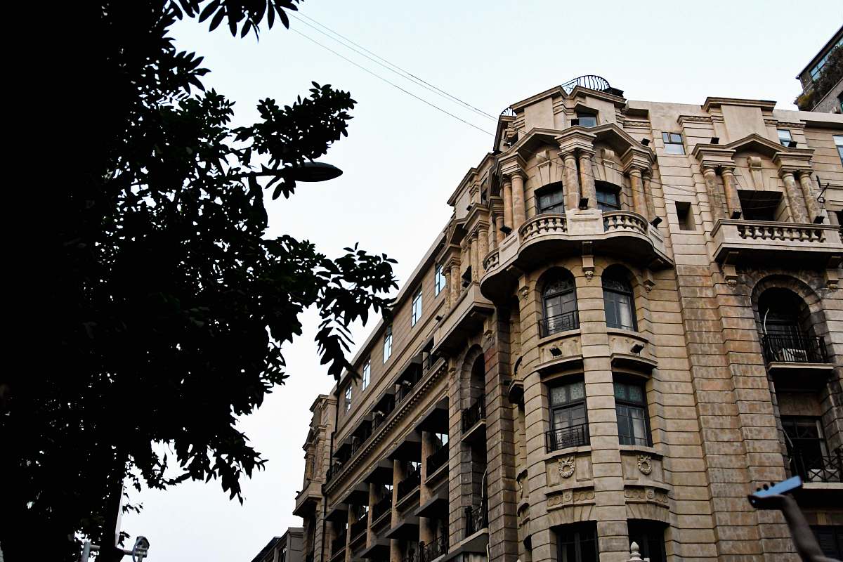 city brown concrete building beside trees high rise