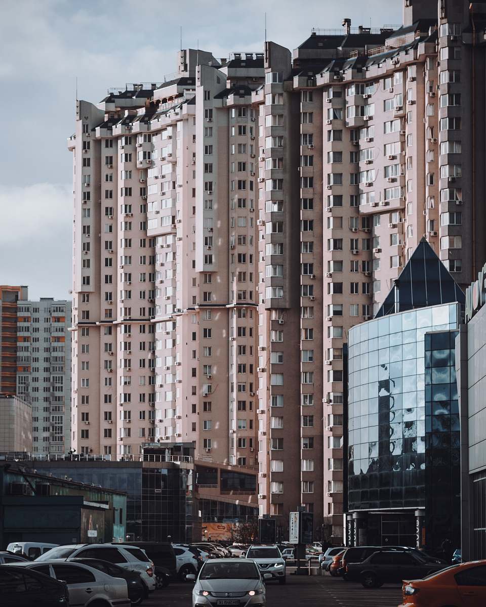 city brown concrete building under cloudy sky high rise
