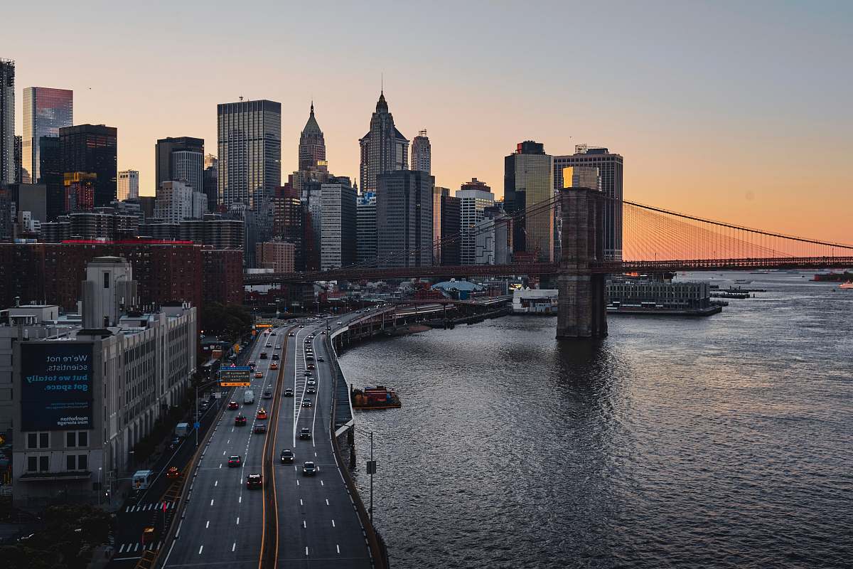 city buildings and road beside body of water urban