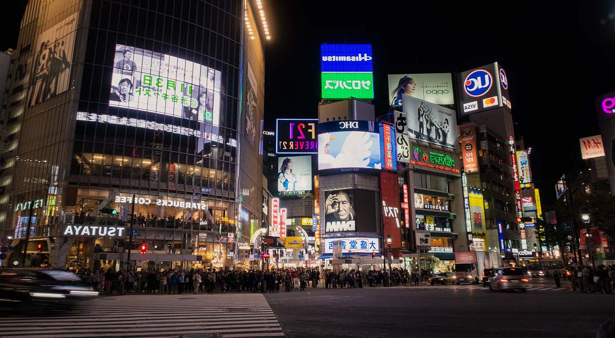 city buildings with signages at night time metropolis