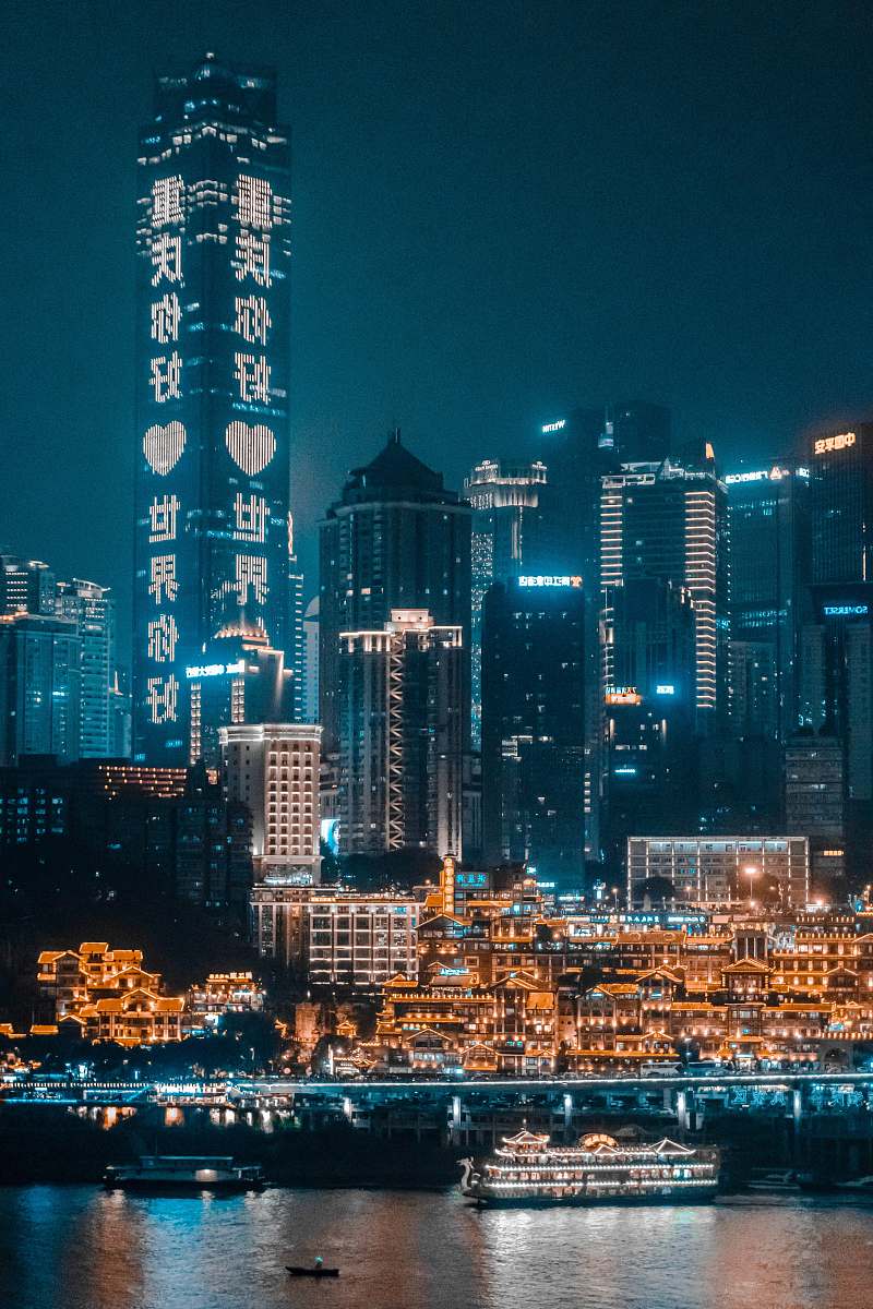city concrete buildings beside body of water during nighttime town