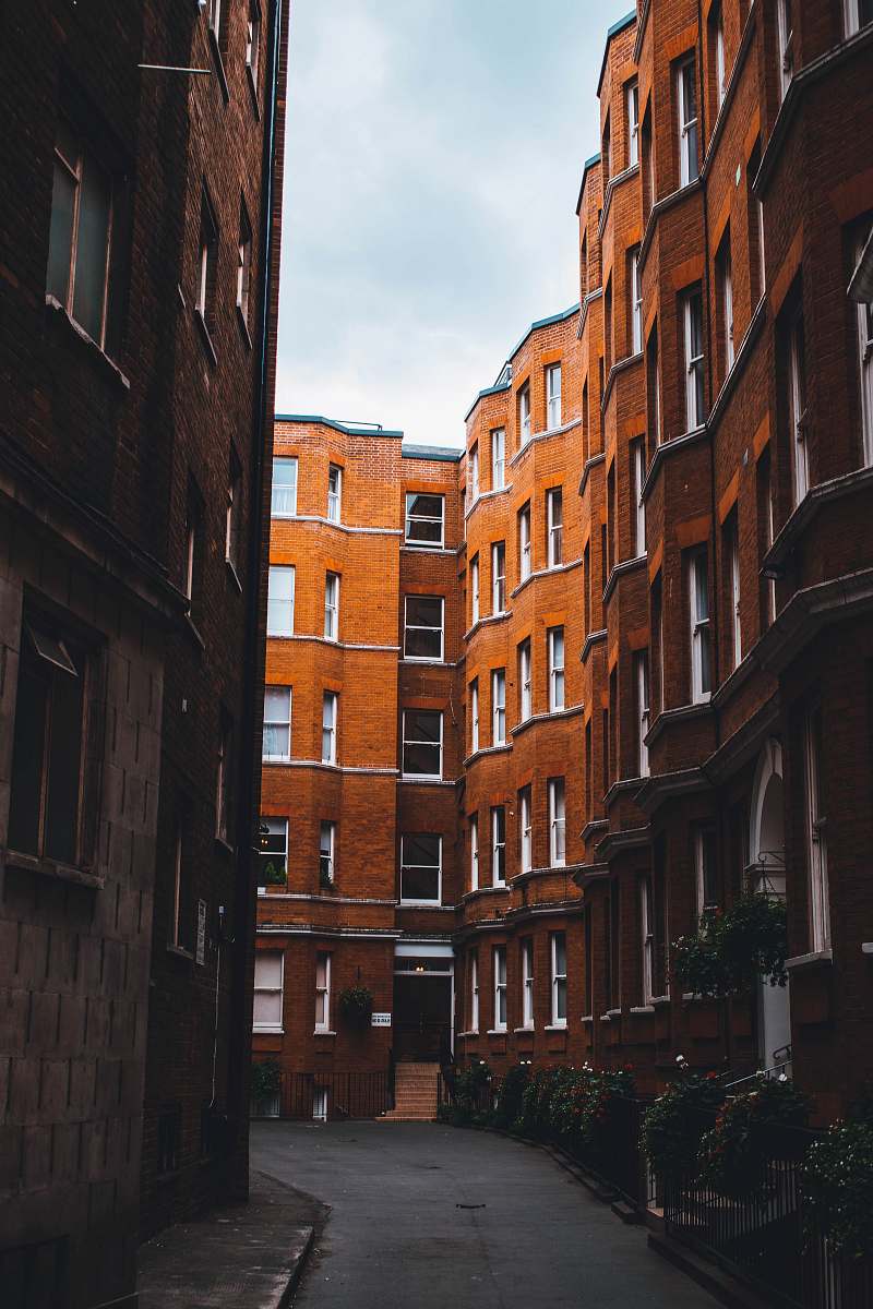 city empty street between brown concrete buildings high rise
