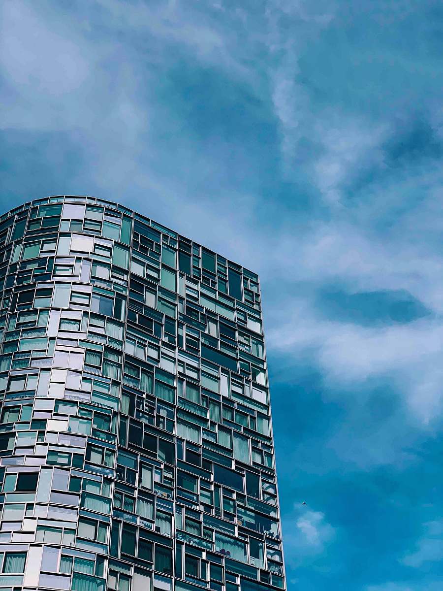 city gray city building under white and blue cloudy sky high rise