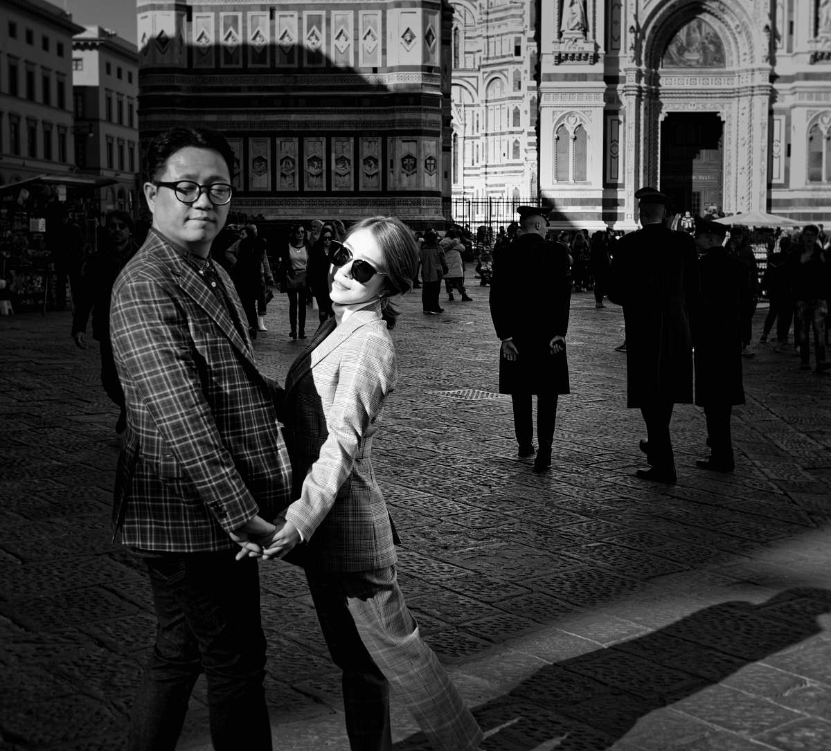 city grayscale photo of people standing in front of building black-and-white