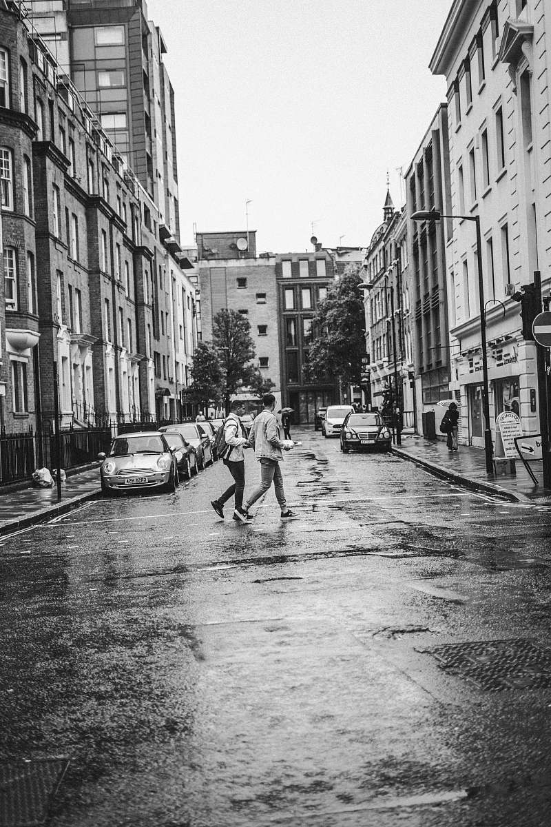city grayscale photo of person walking on road black-and-white