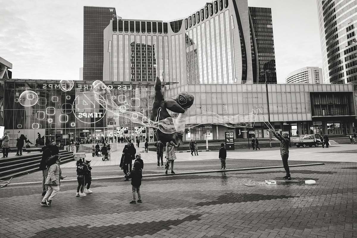 city grayscale photography of person making bubbles black-and-white