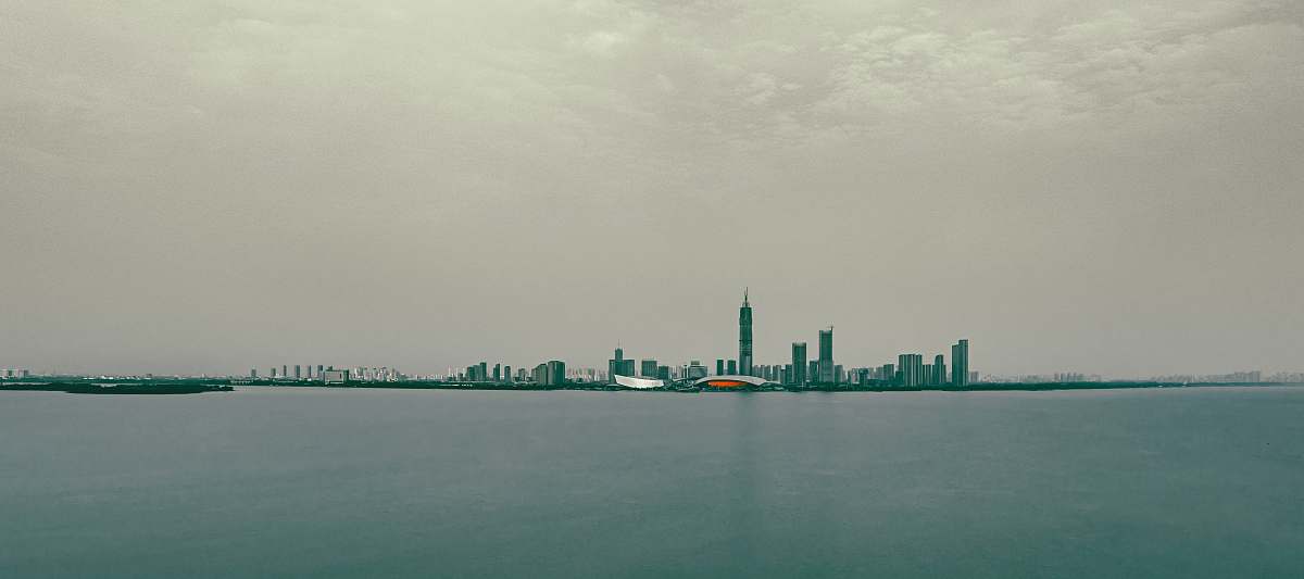 city grey concrete building near body of water during daytime metropolis