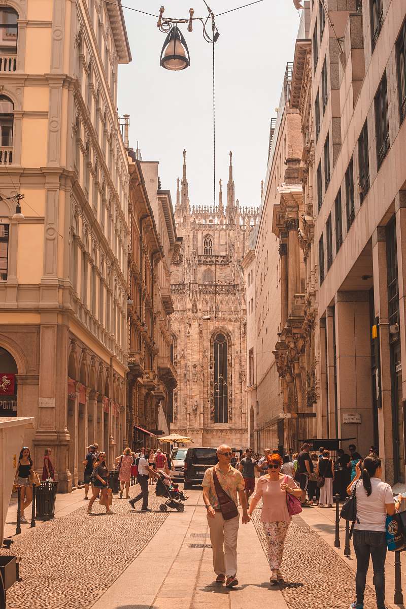 city group of people walking on street in between of buildings person