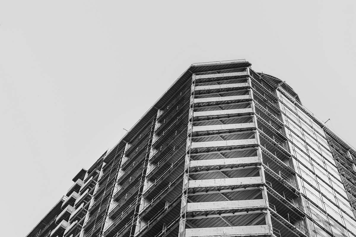city low-angle grayscale photography of concrete building during daytime black-and-white