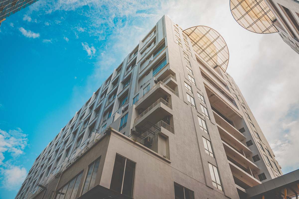 condo low angle photo of beige high rise building housing