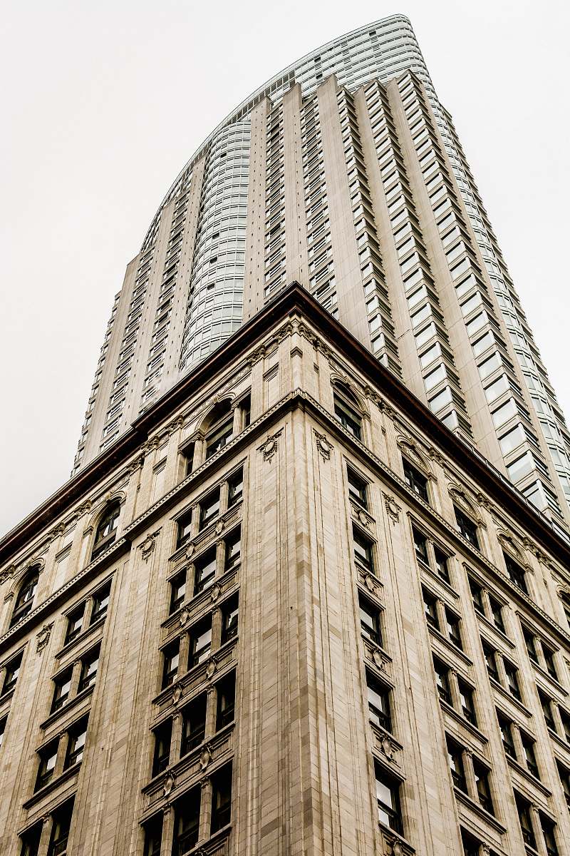 city low angle photo of high rise building under gray sky architecture