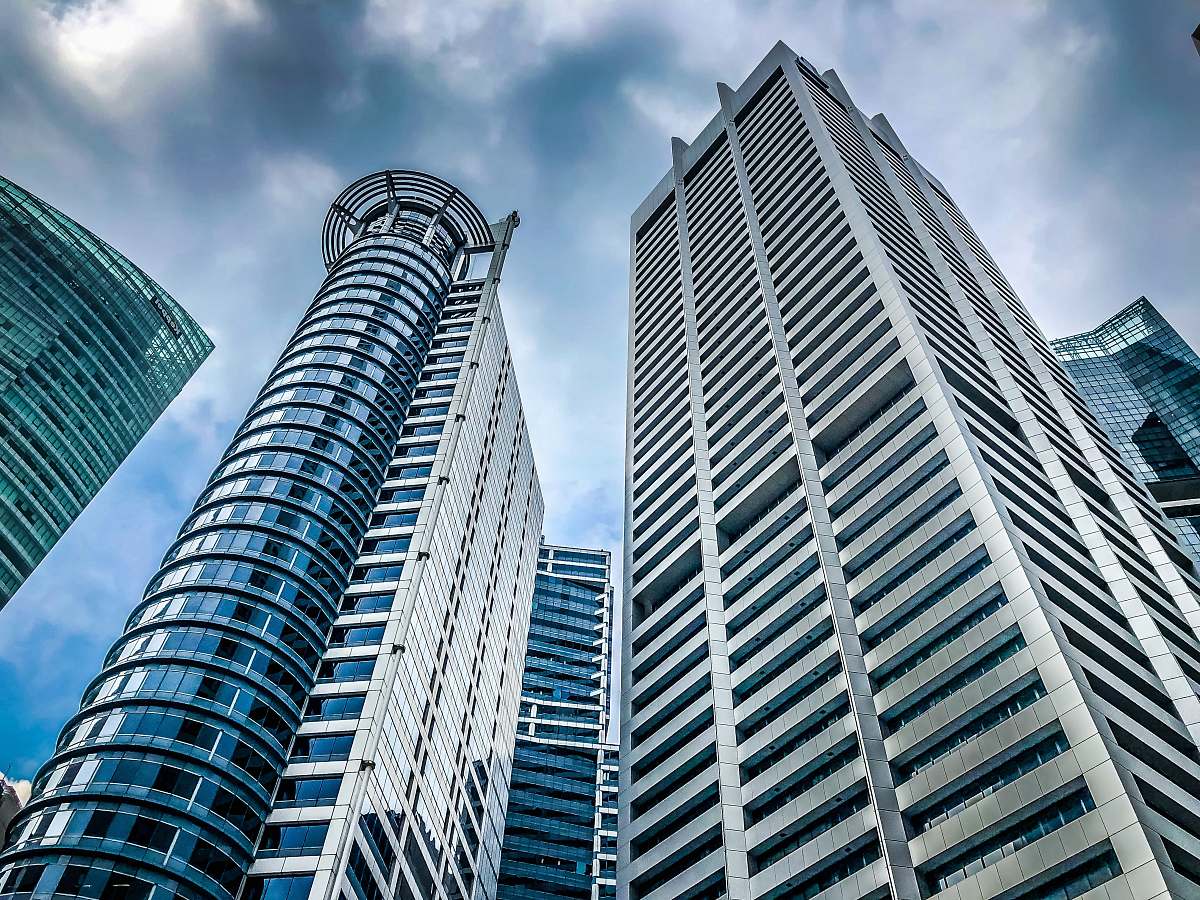 city low angle photo of high rise buildings under grey cloudy sky high rise
