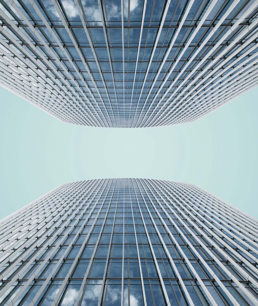urban low angle photo of high rise glass building at daytime city