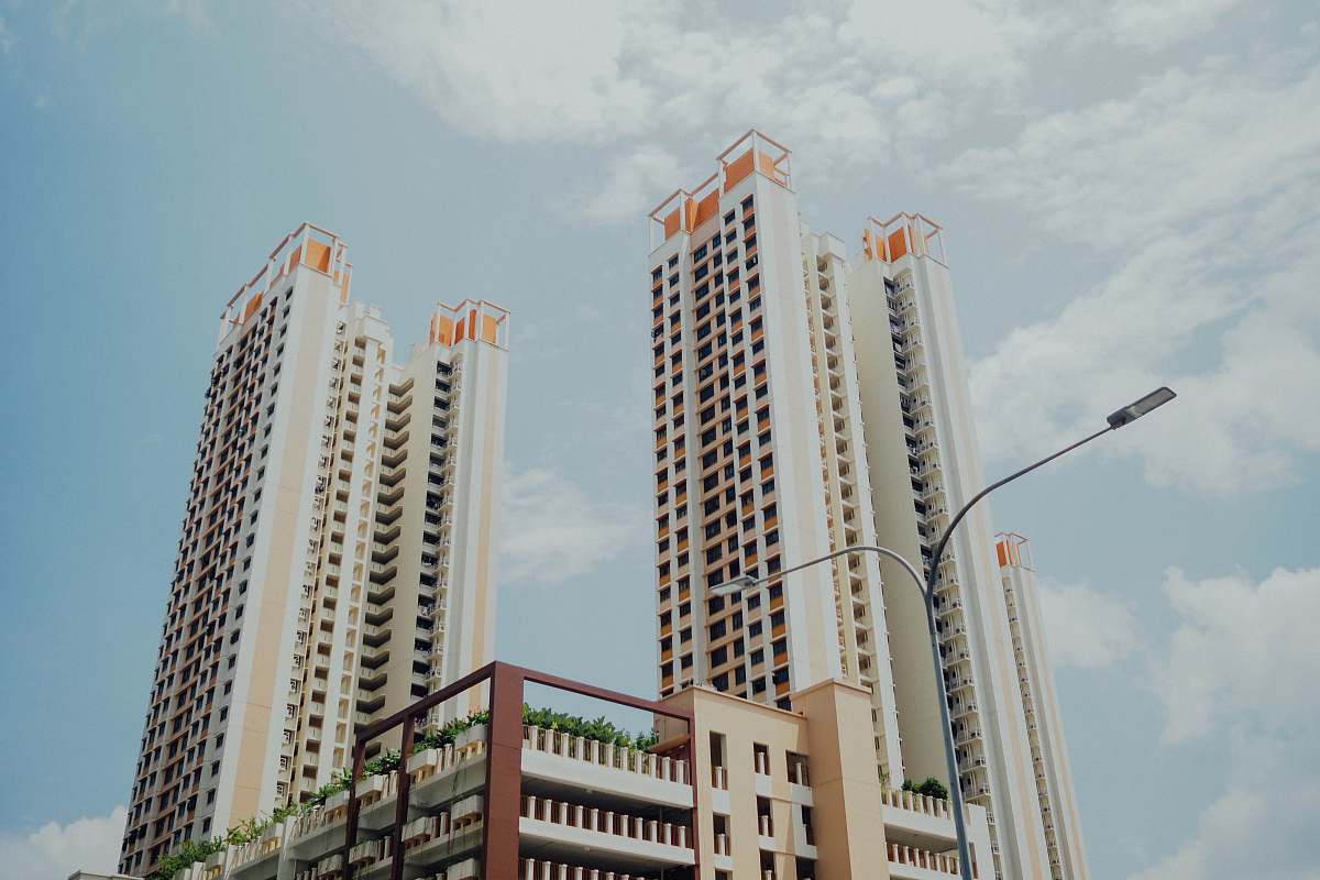 urban low-angle photo of white highrise buildings under blue loudy sky high rise