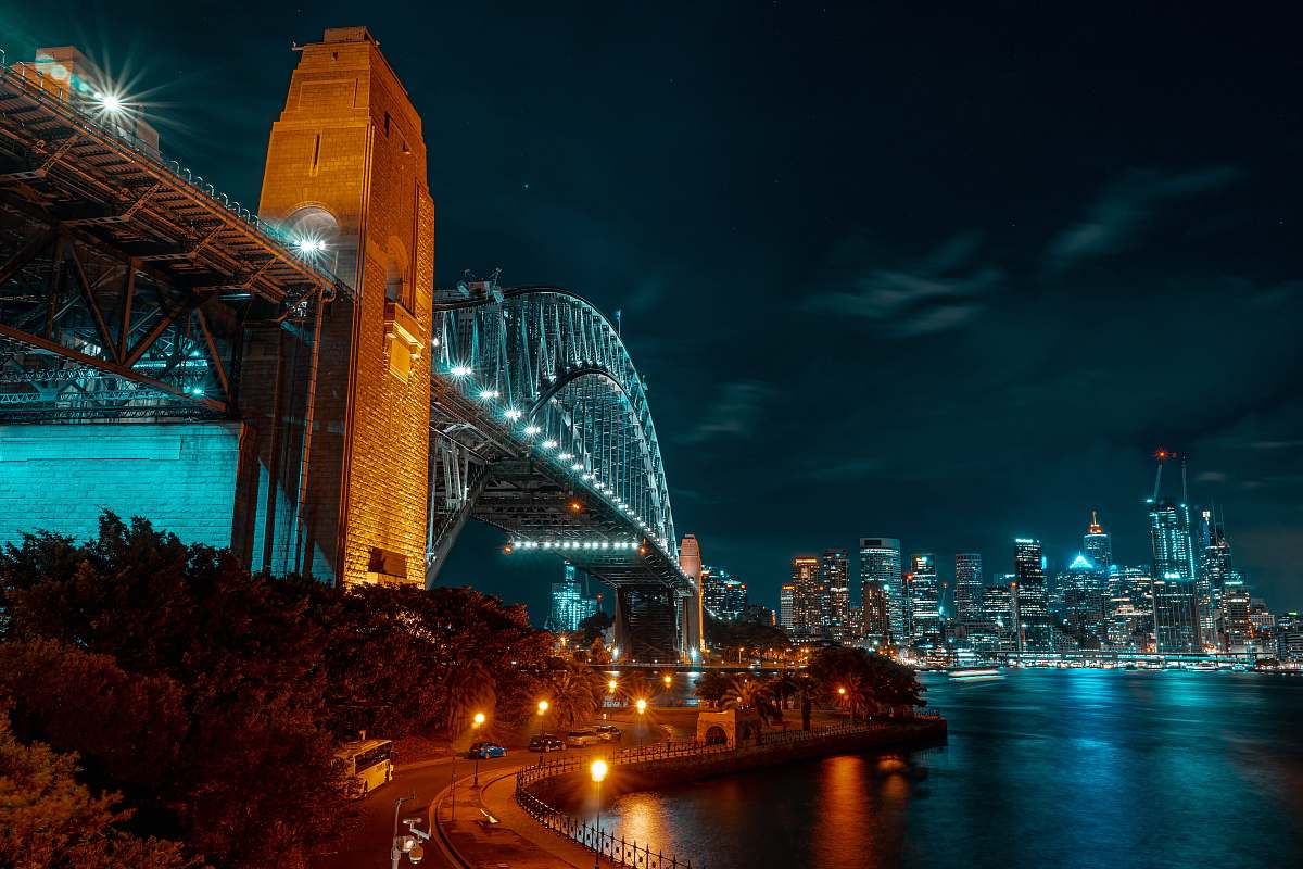 metropolis low-angle photograph of concrete and metal bridge at nightr town
