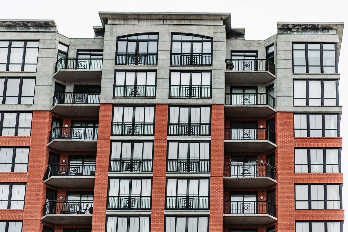 city low-angle photography of brown and gray concrete midrise building during daytime high rise
