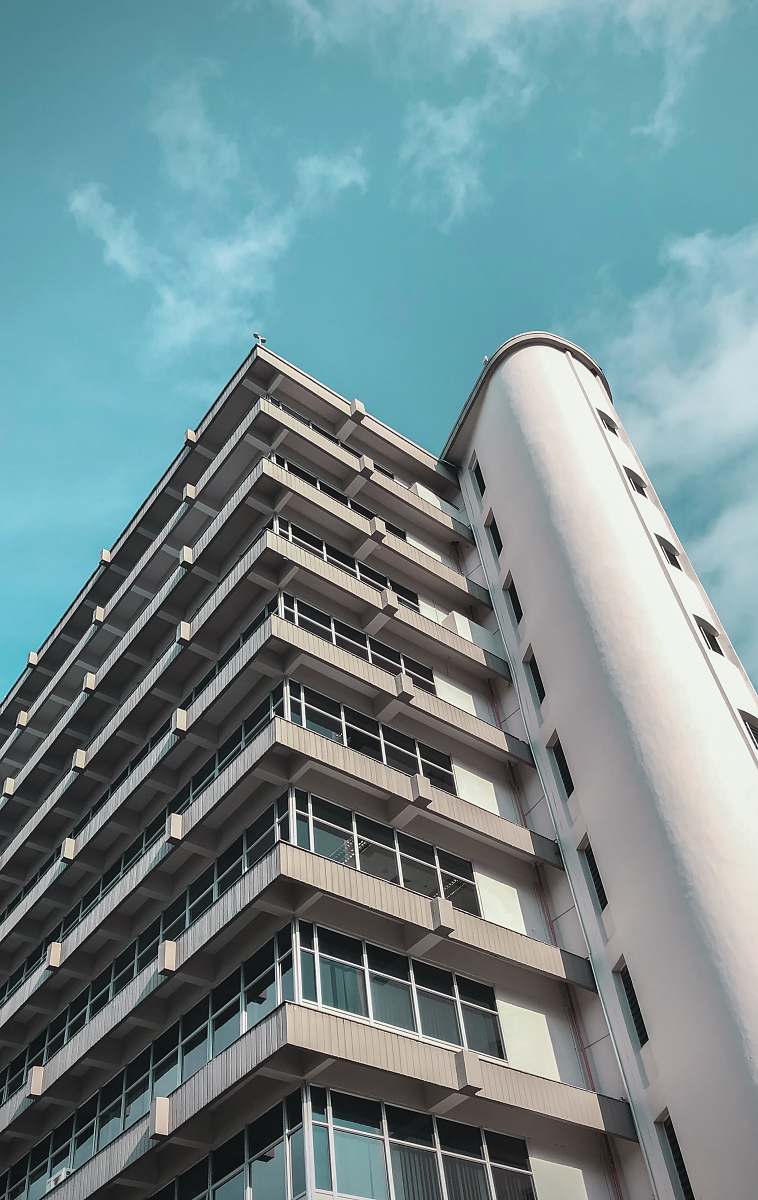 condo low-angle photography of white high-rise building under blue and white sky during daytime housing