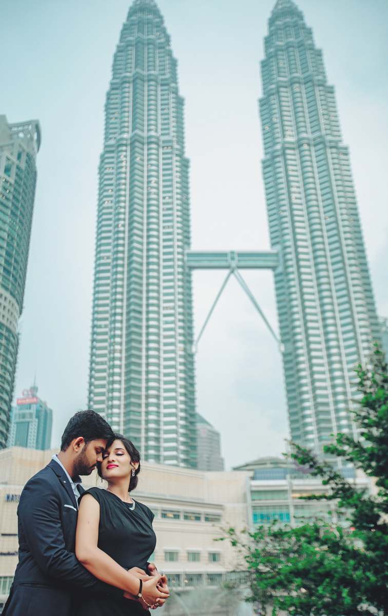 city man and woman standing near Petronas Tower, Malaysia high rise
