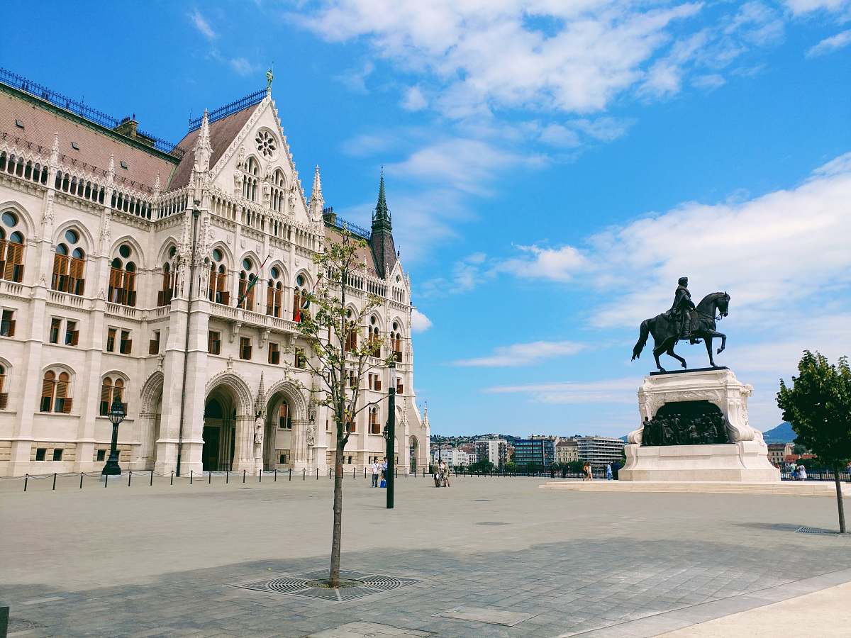 city man riding horse statuette in front of building downtown