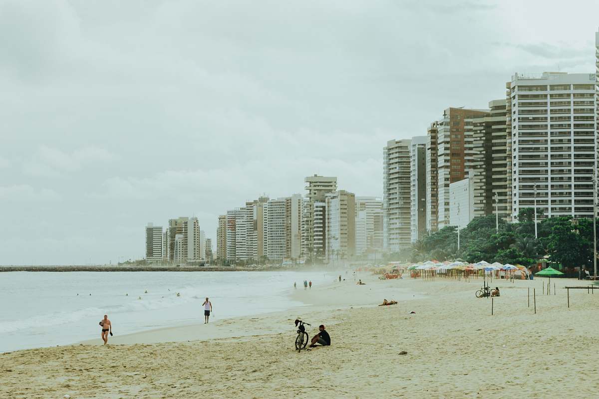 city man sitting beside bicycle on shore high rise