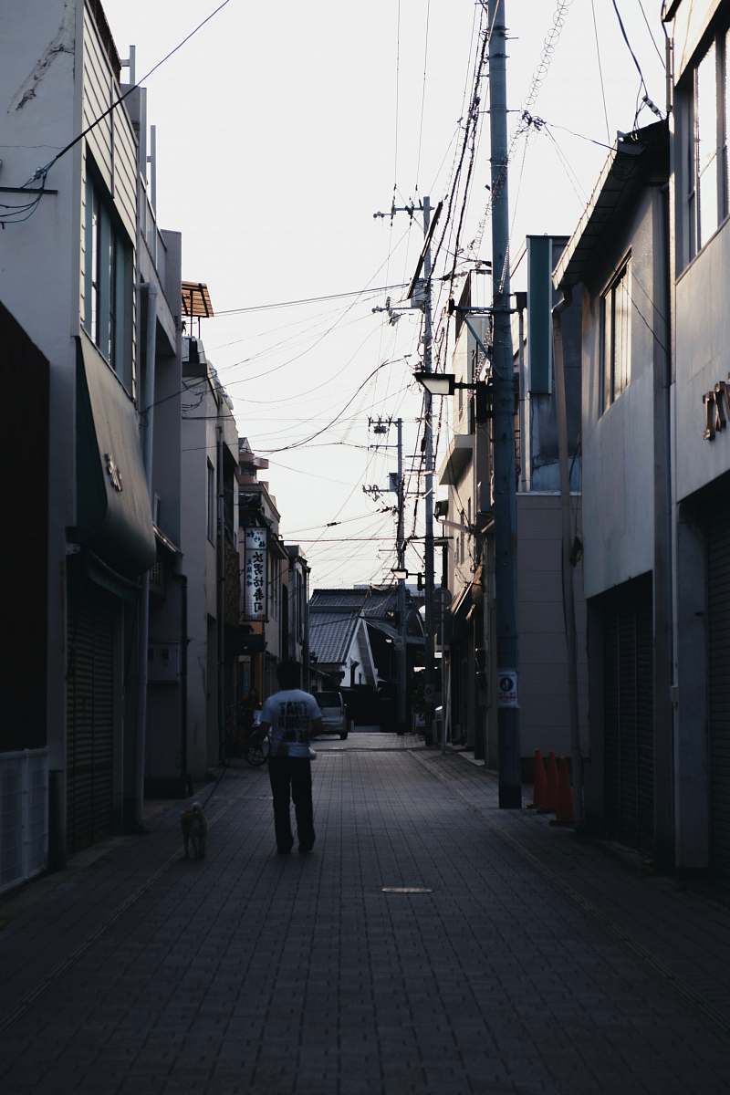 city man standing between alley road
