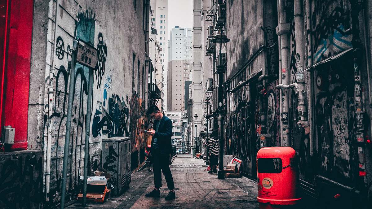 city man standing between buildings road