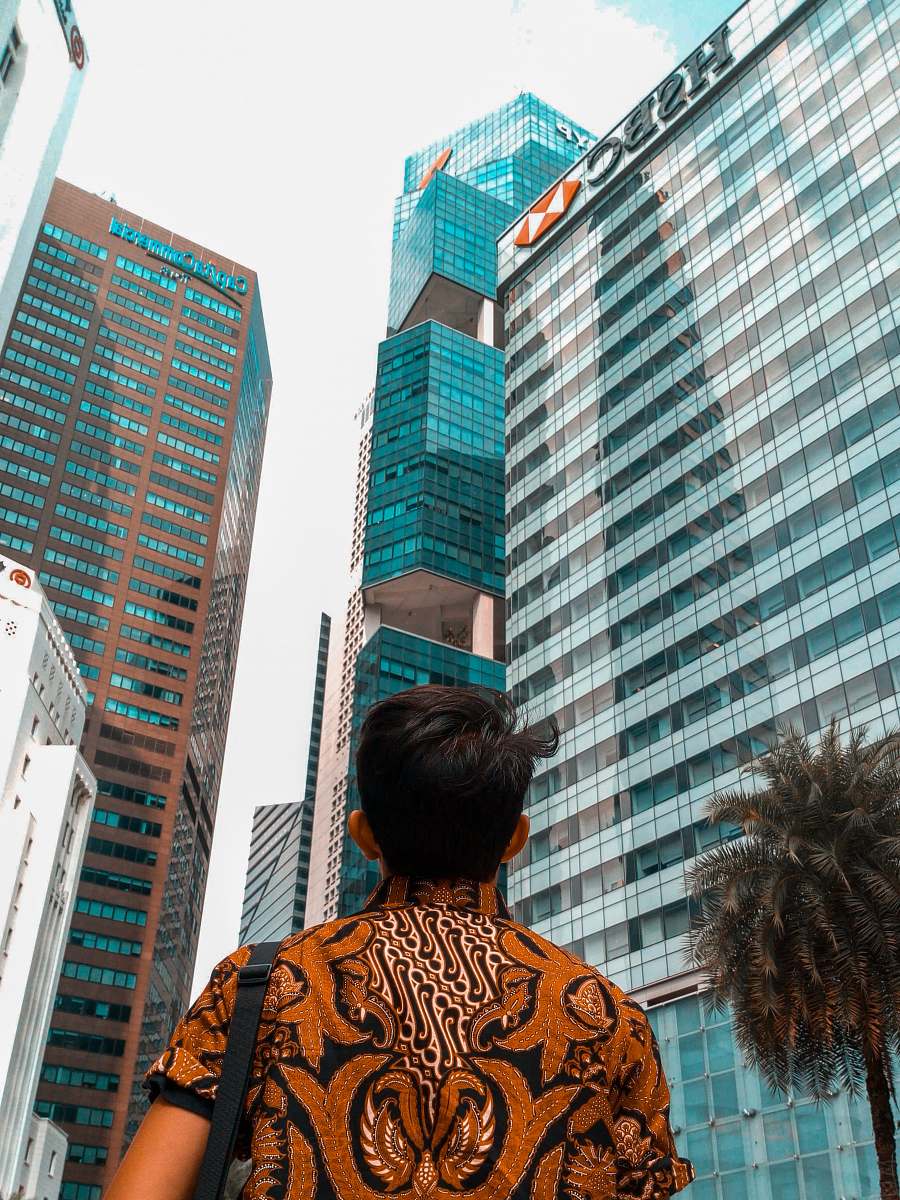 city man standing front of curtain wall building office building