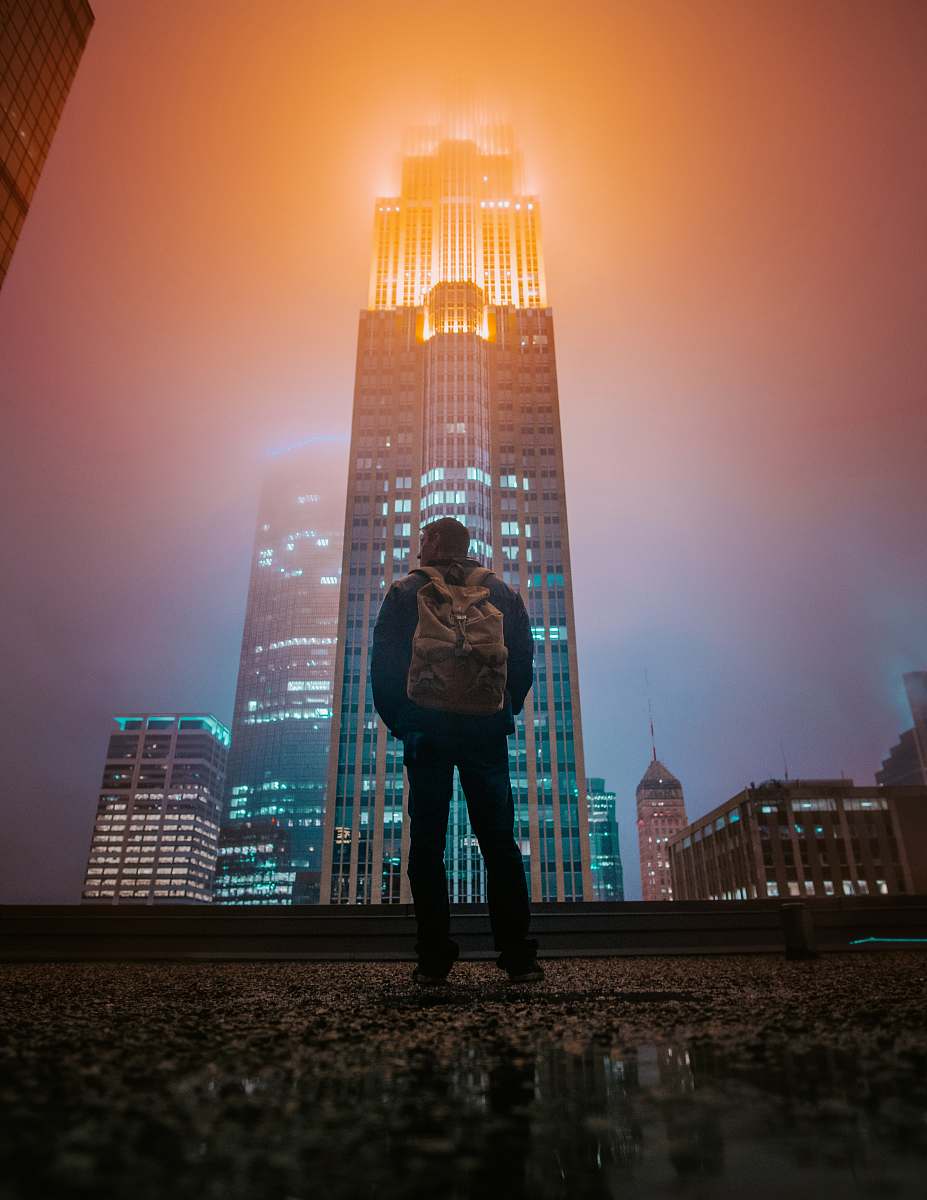 city man standing while facing building urban