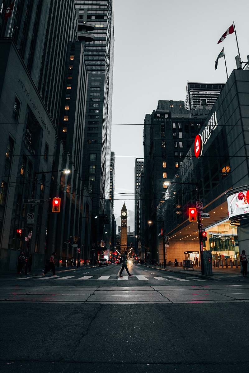 city man walking across pedestrian lane between buildings road