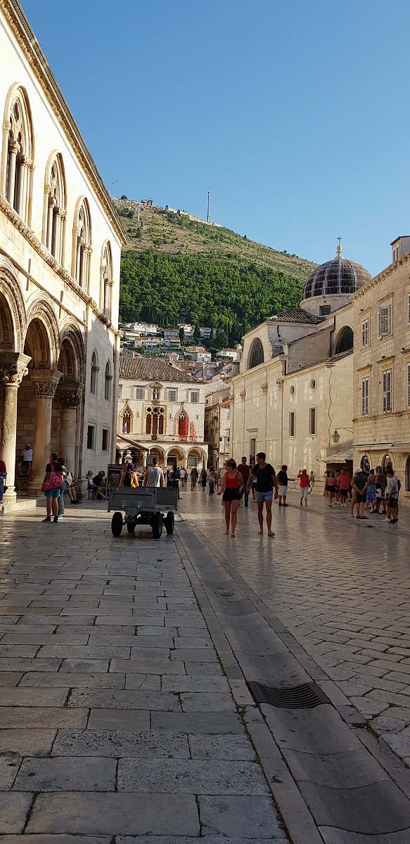 city people near brown building under blue sky during daytime downtown