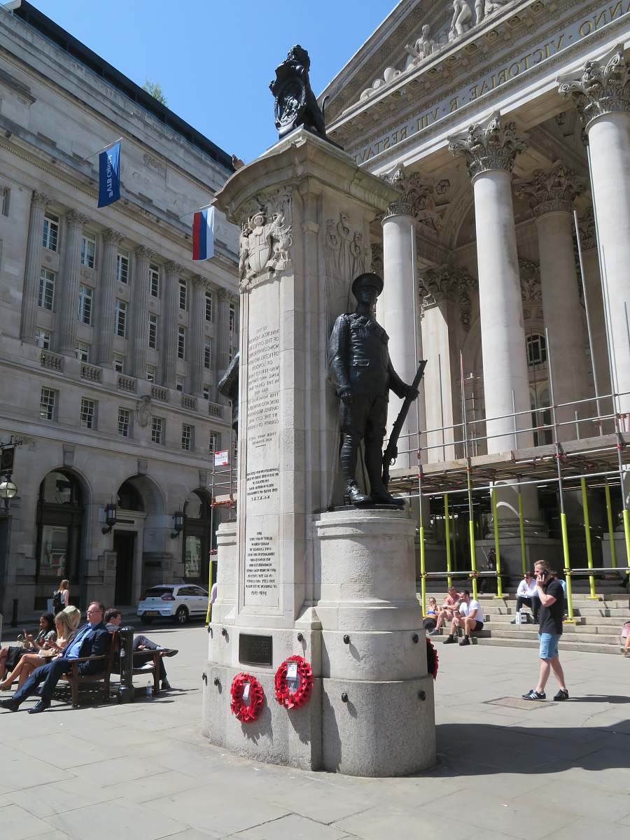 human people sitting on bench beside monuments near buildings person