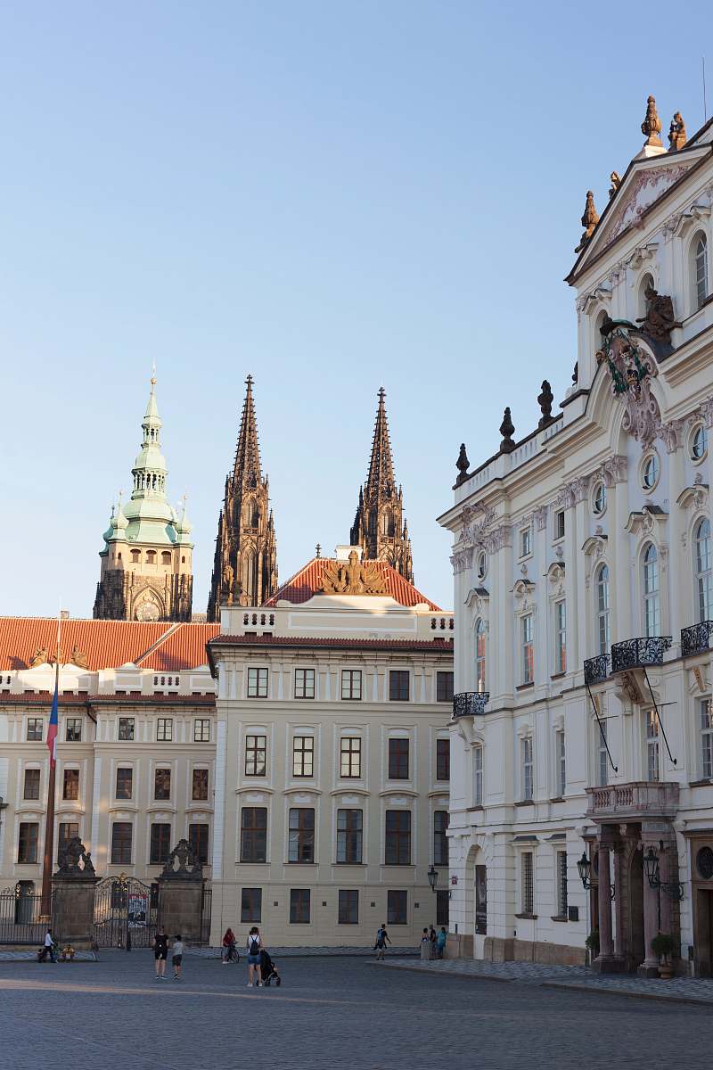 city people standing near white concrete building under blue calm sky downtown
