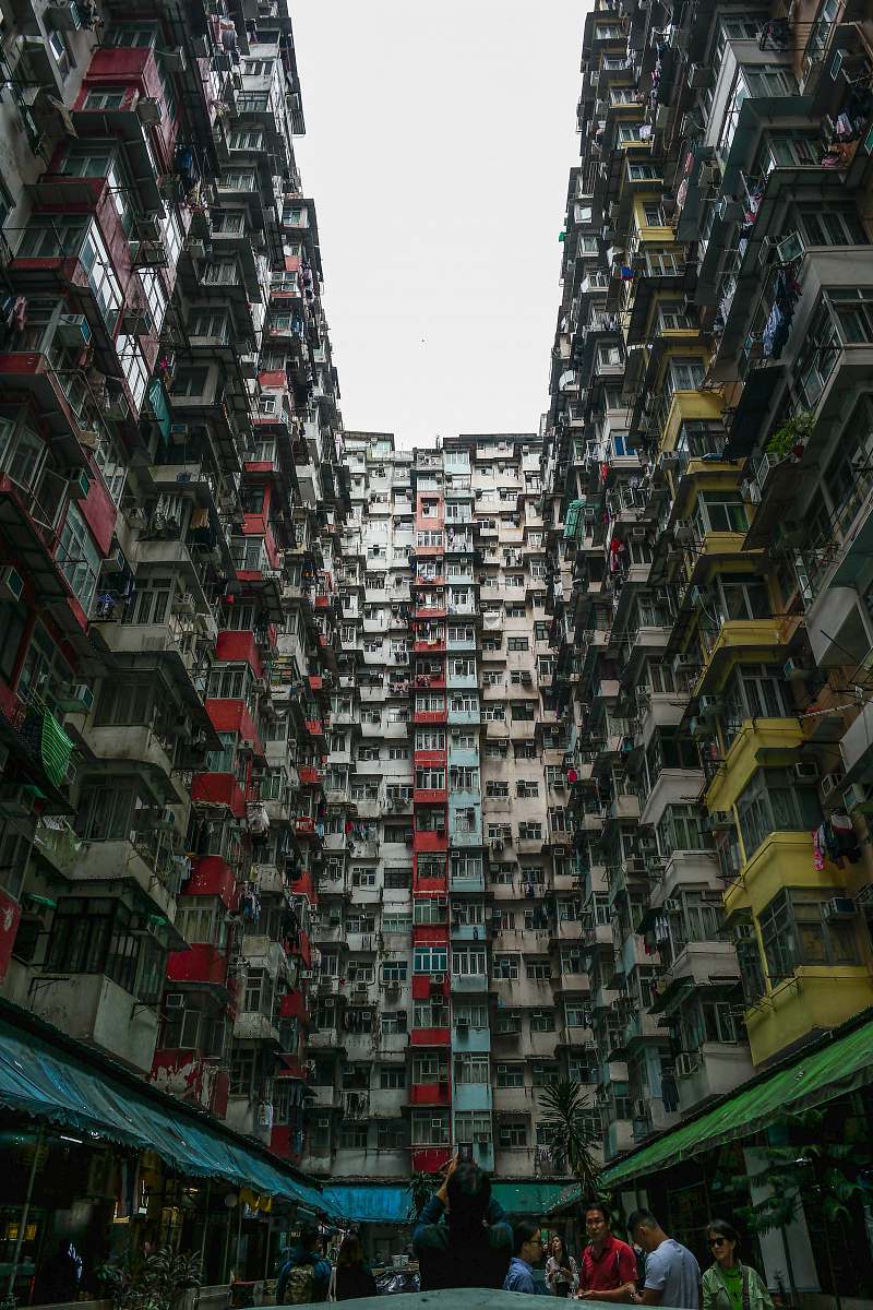 city people standing outside high-rise building during daytime high rise