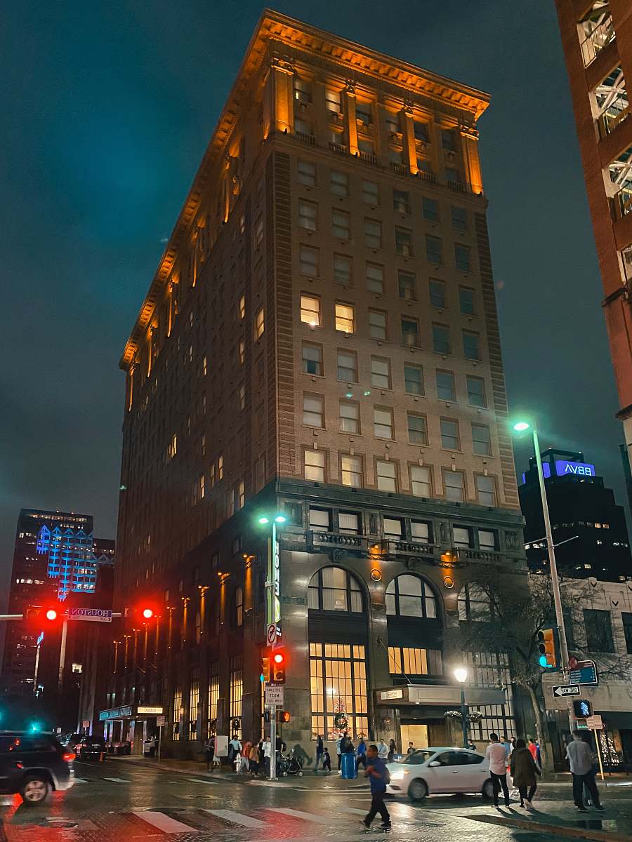 city people walking beside brown concrete building downtown