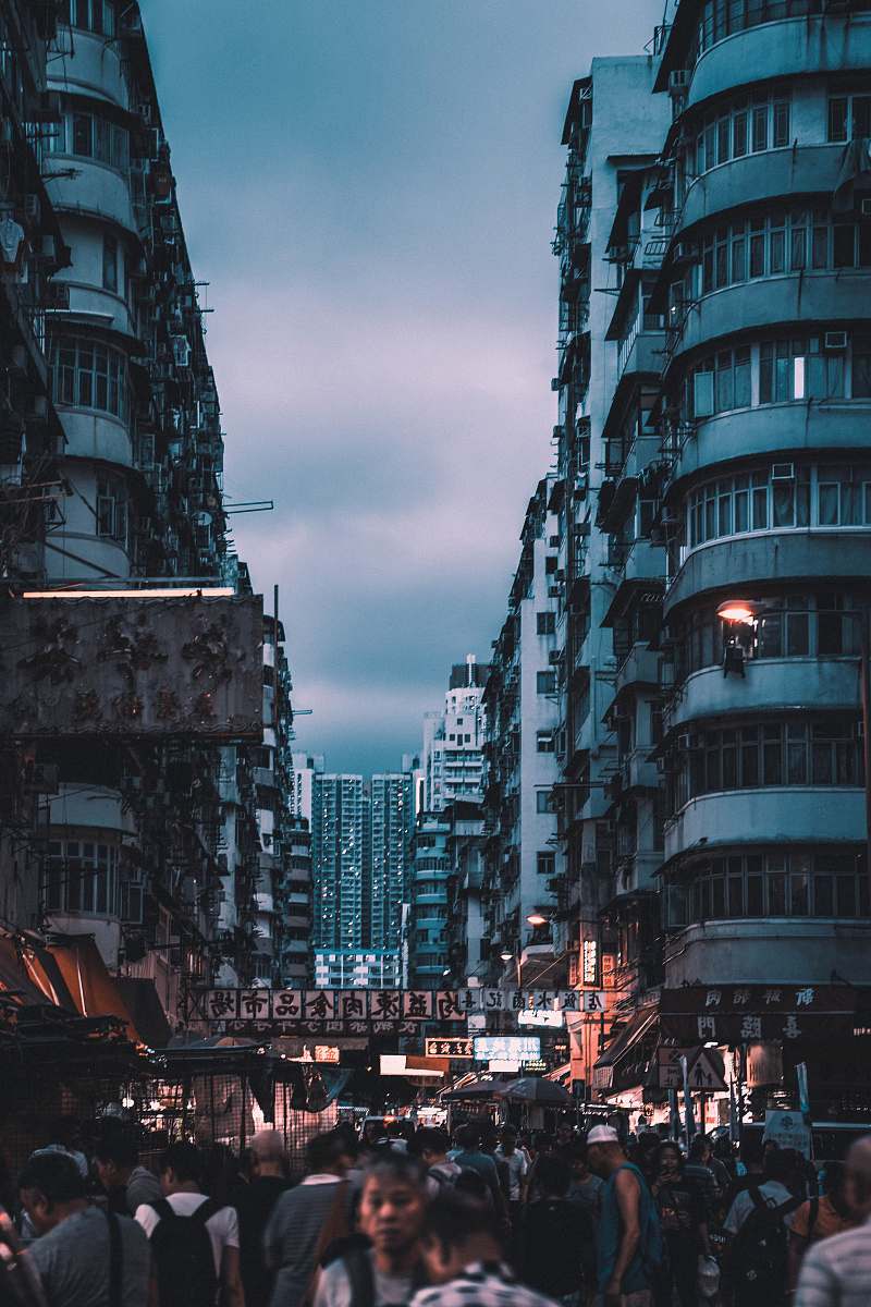city people walking between buildings during nighttime metropolis