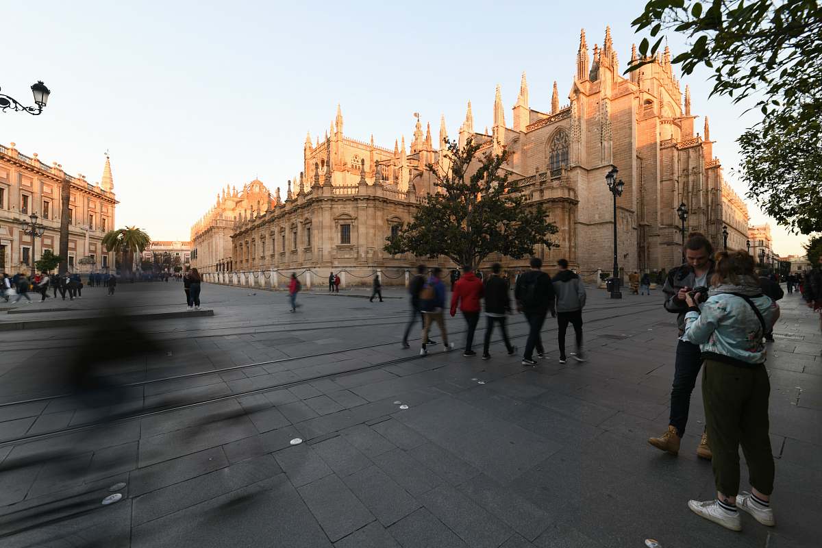 city people walking near brown concrete church during daytime downtown