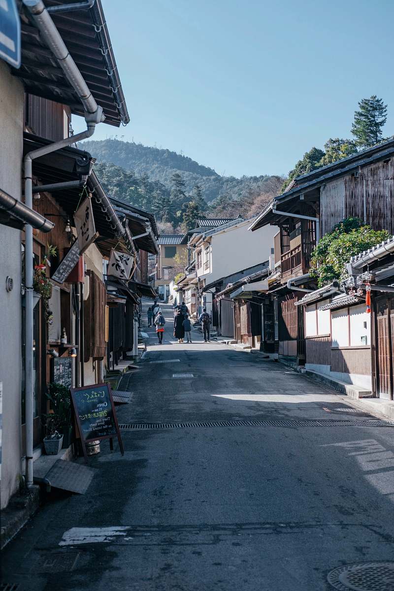 city people walking near houses during daytime road