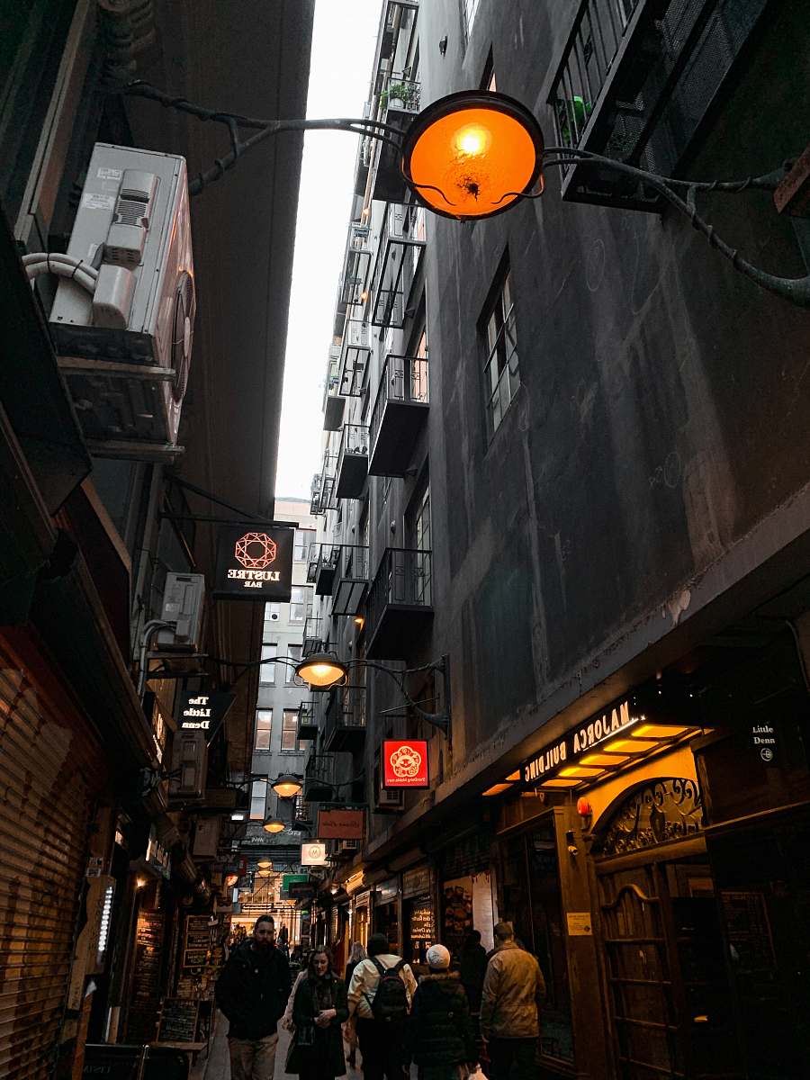 city people walking near street beside high-rise buildings during night time road