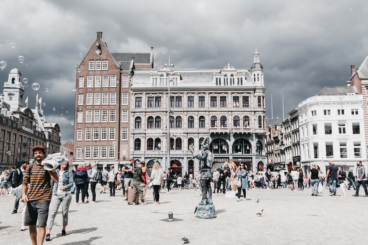 city people walking near white historic buildings during daytime downtown