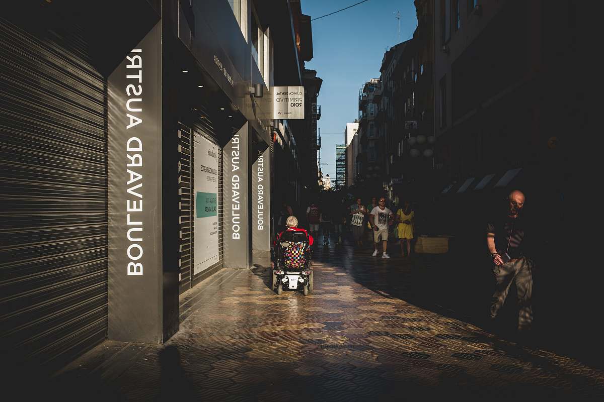 city people walking on pathway near buildings road