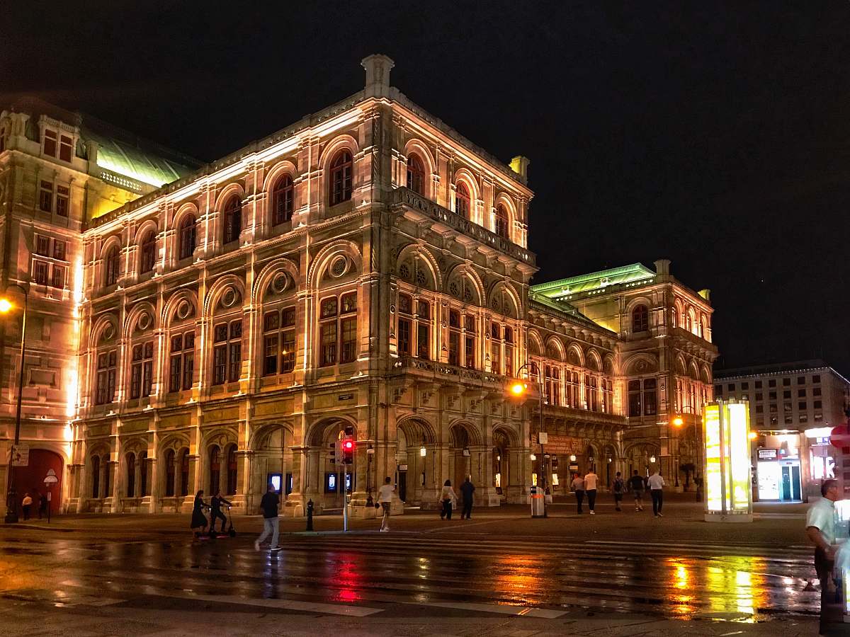 downtown people walking on road near Vienna State Opera during night time city